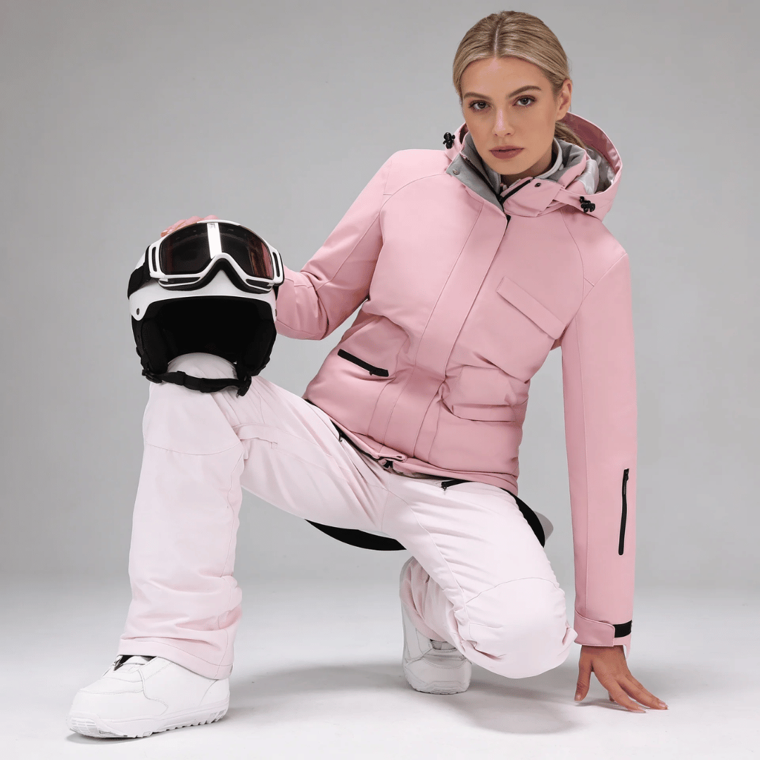 Veste de ski femme et salopette à bretelles portées sur la neige