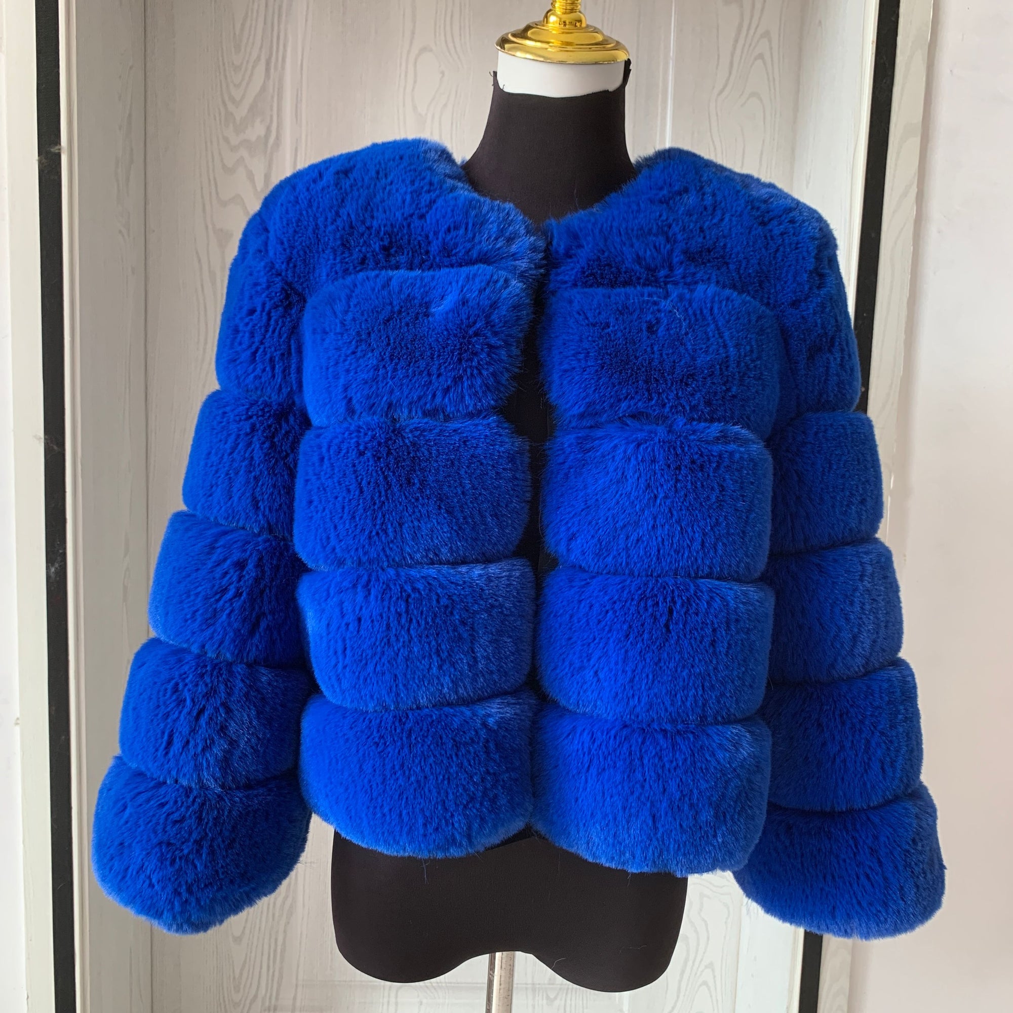 Manteau femme en fausse fourrure porté ouvert sur une tenue d'hiver